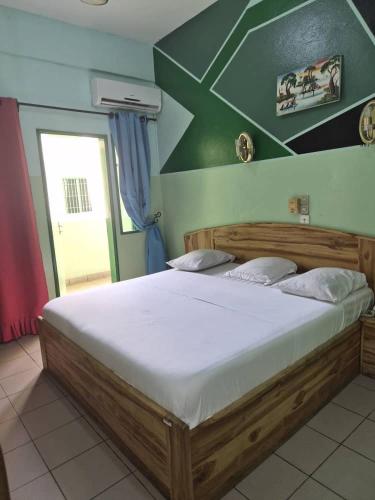 a bedroom with a large bed with a white mattress at Hotel JB&G in Cotonou