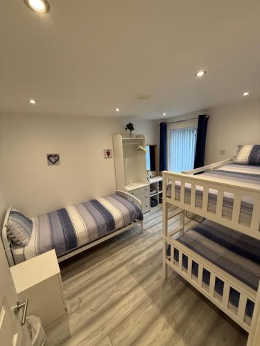 a bedroom with two bunk beds and a desk at Ballycastle, Beachside Apartment in Ballycastle
