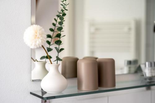 a shelf with three vases and a flower in a mirror at Bolter Mühle - DZ Hanfbuchte in Rechlin