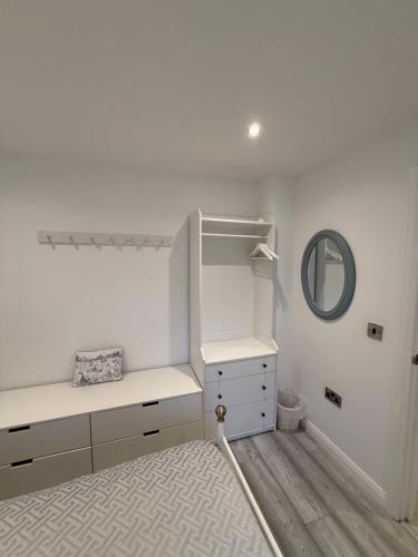 a white room with a desk and a mirror at Ballycastle, Beachside Apartment in Ballycastle