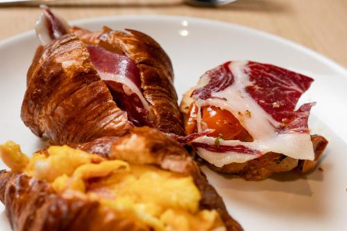 a plate of food with croissants on a table at Hotel Atari in San Sebastián