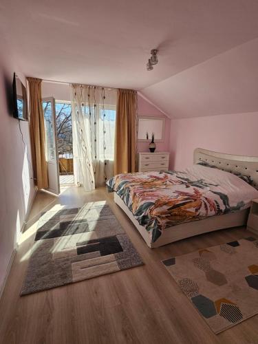 a bedroom with a bed and a large window at Vila Pângărați in Pangarati