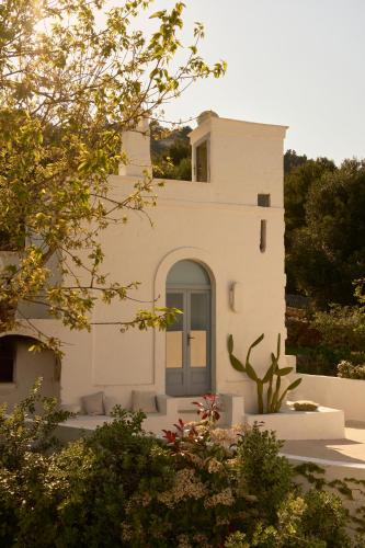 a white building with a blue door in front at Torretta Le Feritoie - piscina e terrazza vista mare in Fasano