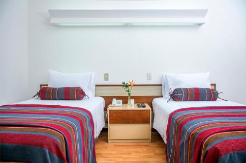 two beds sitting next to each other in a room at San Agustin Riviera in Lima