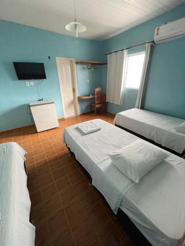 a room with two beds and a television in it at Plaza Hotel in Itaituba