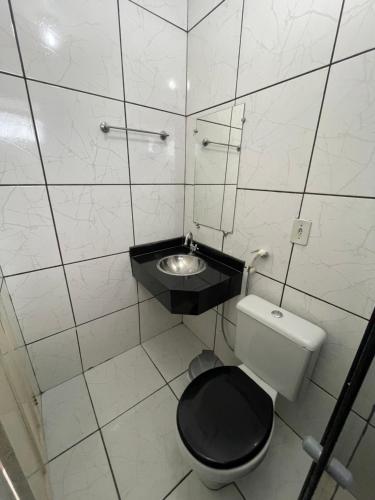 a small bathroom with a toilet and a sink at Plaza Hotel in Itaituba