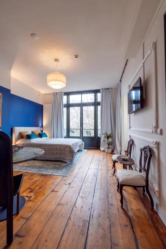 a bedroom with two beds and a wooden floor at Aparthotel Jacques van Marken Erfgoed in Delft