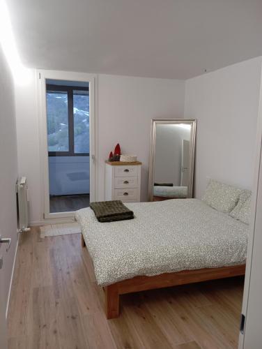 a white bedroom with a bed and a mirror at Il rifugio del cuore in San Massimo