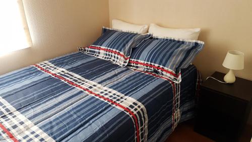 - un lit avec une couette et des oreillers bleus et blancs dans l'établissement Lima Flats 2, à Lima