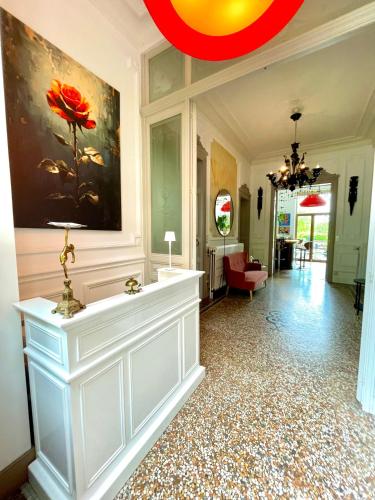 ein Flur mit einem Gemälde einer roten Blume an der Wand in der Unterkunft Villa O in Virton