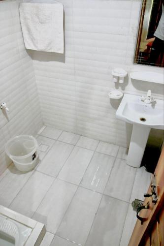 a white bathroom with a toilet and a sink at Shangrella Hotel Malam Jabba in Malam Jabba