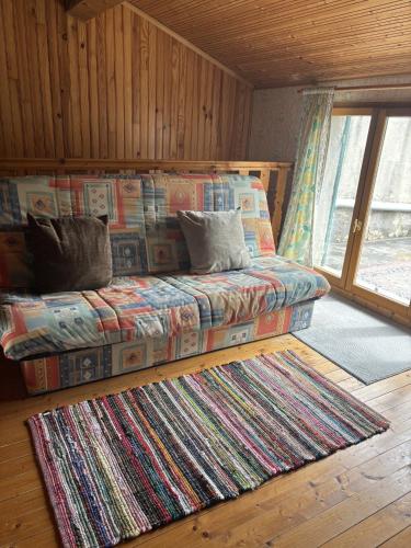 a bed in a room with a rug at La Digeonne in Chabeuil