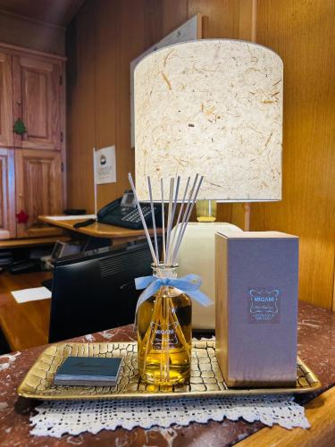 a lamp sitting on a table with a box and a candle at Centrale in Courmayeur