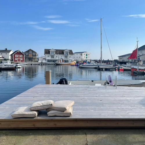 two pillows on a dock with a marina with boats at Seaside Boathouse In Veiholmen in Smøla