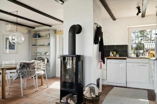 a kitchen with a wood stove in the middle at Stone House's Simplicity In Jerup's Vicinity in Jerup