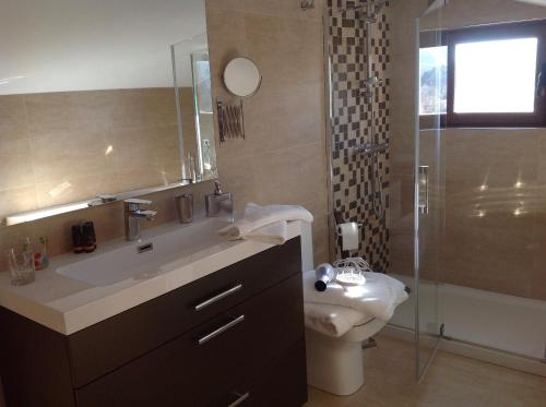 a bathroom with a sink and a toilet and a shower at Apartment Valle de Cepeda in Cepeda