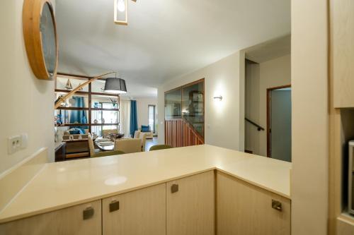 a kitchen with white countertops and a living room at Chic poolside haven 3BR steps from the beach in Cap Malheureux