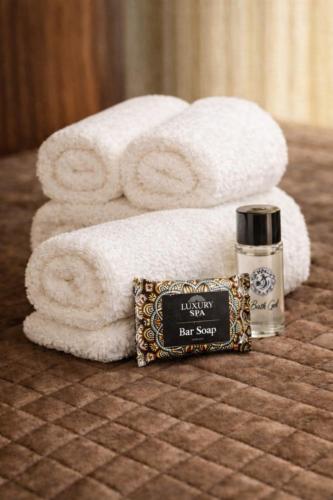 a pile of towels and a bottle of nelson bathroom bar soap at MARY'S HOUSE The lux terrace in Tripoli