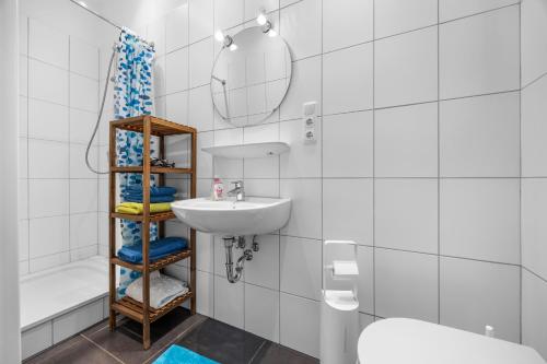 a bathroom with a sink and a toilet and a mirror at Ferienwohnung Edo Wiemken in Jever