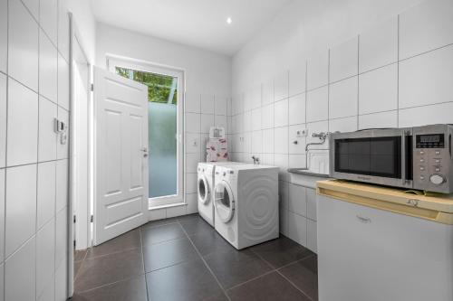 a kitchen with a washing machine and a microwave at Ferienwohnung Edo Wiemken in Jever
