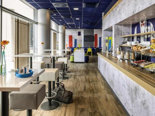 a cafeteria with tables and chairs and a bakery at Ibis budget Hannover Hbf in Hannover