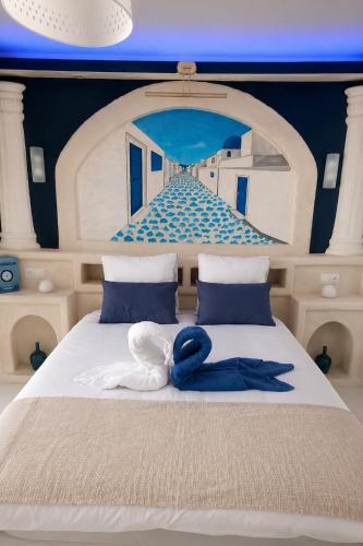 a bedroom with a bed with a painting on it at Le secret de Santorin in Martigues