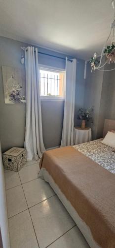 a bedroom with a bed and a window at logement ensoleillé in Cardet