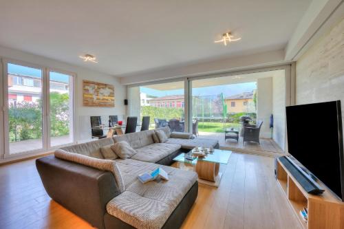 a living room with a couch and a flat screen tv at Rebecca Garden with Terrace in Paradiso - Happy Rentals in Lugano