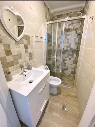 a bathroom with a toilet and a sink and a shower at A Casinha in Portel