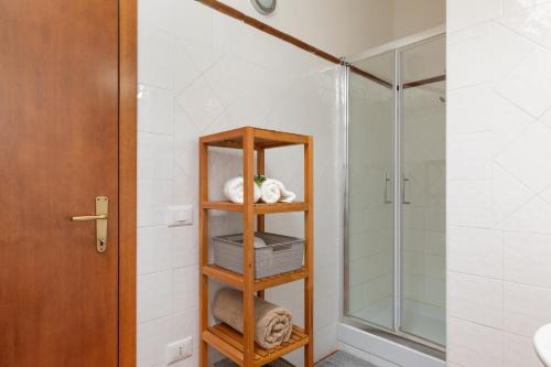 a bathroom with a shower and a shelf with towels at Countryhouse in Tuscany in Chianni