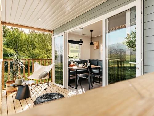 a screened in porch with a table and chairs at Camping 4 étoiles - ccbg0ic in Saint-Éloy-les-Mines