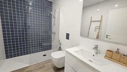 a bathroom with a toilet and a sink and a shower at Costa Nova Azul in Gafanha da Encarnação