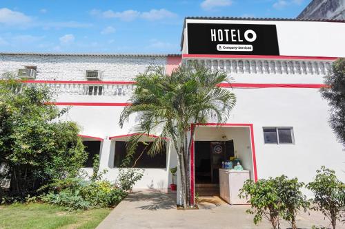 a hotel with a palm tree in front of a building at Hotel O Singar Nagar Metro Station Lucknow Formerly Highway Inn in Alambagh