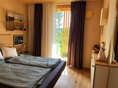 a bedroom with a bed and a large window at Ferienwohnung am Stadtwald in Triberg
