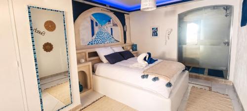 a small bedroom with a bed and a mirror at Le secret de Santorin in Martigues