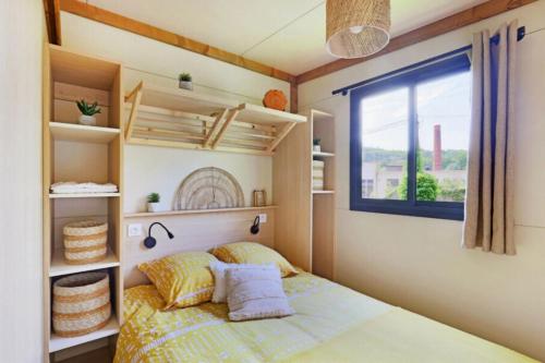 a small bedroom with a bed and a window at Chalet 4 étoiles - Piscine - ccbg00h in Celles-sur-Plaine