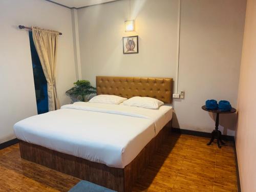 a bedroom with a large bed in a room at สวนไผ่รีสอร์ท in Ban Na