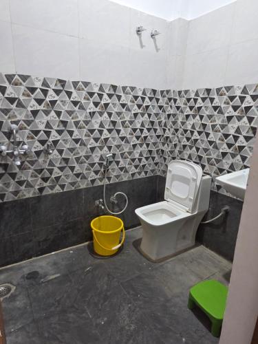 a bathroom with a toilet and a sink and a bucket at Divine House in Lucknow