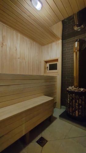 a sauna with a bench in a room at Villa MegaLit - відпочинок у котеджах з чанами біля Косино та Берегово in Velyka Bihanʼ