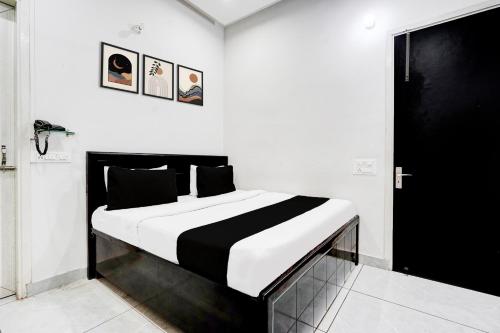 a bedroom with a black and white bed in a room at Super Hotel O Panipat Railway Station Formerly Atithi in Pānīpat