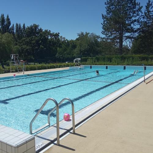 a large swimming pool with people in the water at Camping du pont d'Oust in Peillac