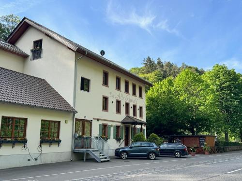 two cars parked in front of a building at Die "Alte Schmelz"- Boutique-Landhotel & Restaurant in Bad Dürkheim