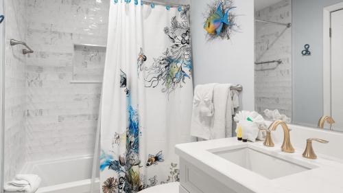 a white bathroom with a sink and a shower curtain at 4409 Ocean Pointe Suites in Tavernier