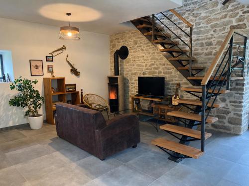 a living room with a couch and a spiral staircase at At Home in Cruguel