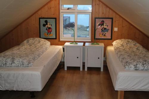 two beds in a room with two windows at RVK HoriZon in Álftanes