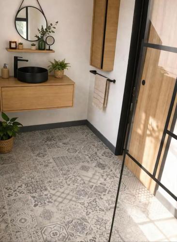 a bathroom with a sink and a mirror at At Home in Cruguel