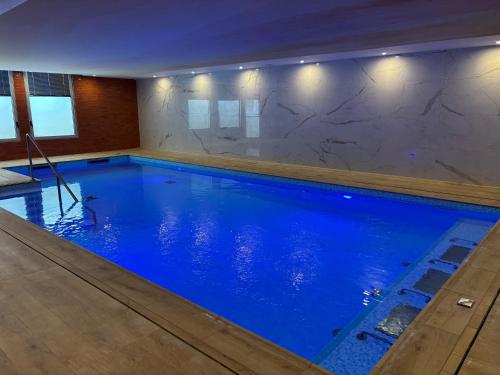 a large swimming pool with blue water in a building at DOMITYS - Villa Caron - AEROPORT ORLY in Athis-Mons