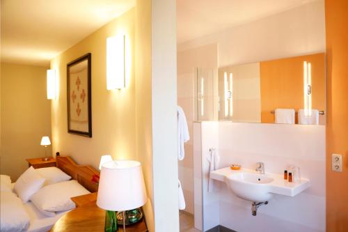 a bathroom with a sink and a bed in a room at Gästehaus im Flüsterbogen in Görlitz