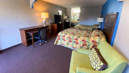 a hotel room with a bedroom with a desk and a bed at Magnuson Hotel Marietta in Marietta