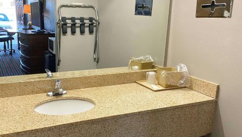 a bathroom counter with a sink and a mirror at Magnuson Hotel Marietta in Marietta